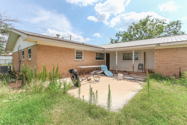 207 W Robinson Rd, Big Spring, TX 79720 - rear view of property featuring a patio area, brick siding, and a metal roof