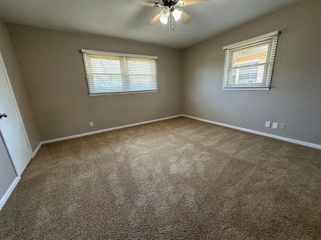 carpeted spare room featuring ceiling fan and a healthy amount of sunlight