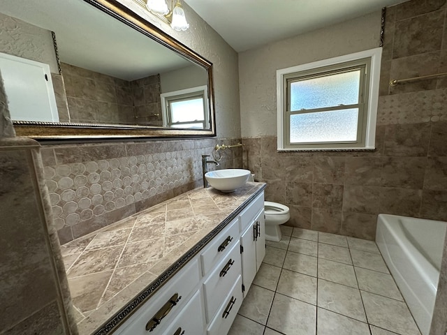 bathroom with vanity, tile patterned floors, a wealth of natural light, and tile walls