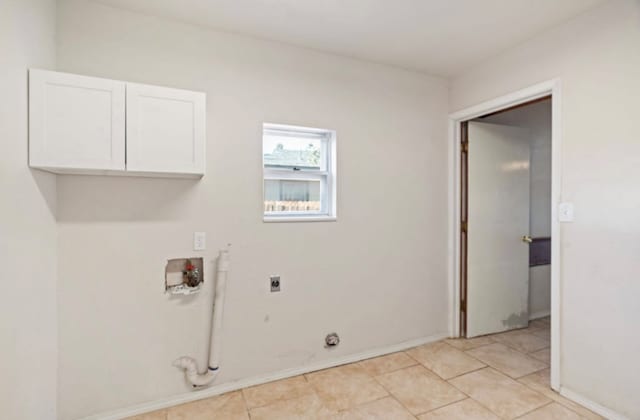 laundry area featuring gas dryer hookup, cabinets, washer hookup, light tile patterned floors, and hookup for an electric dryer