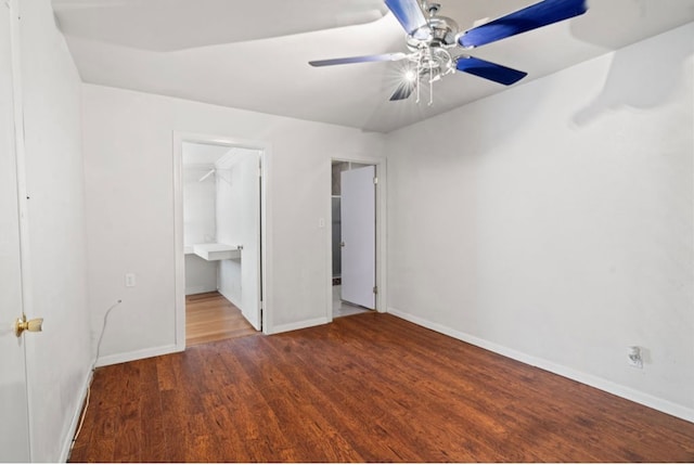 unfurnished bedroom with ceiling fan, a spacious closet, connected bathroom, wood-type flooring, and a closet