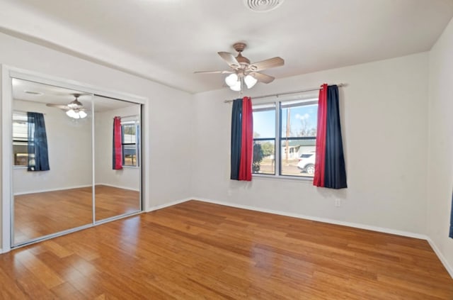 unfurnished bedroom featuring ceiling fan, a closet, and hardwood / wood-style floors