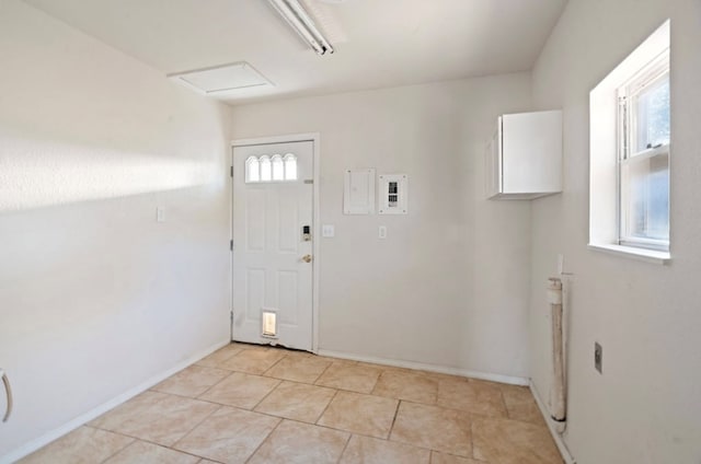 clothes washing area featuring a healthy amount of sunlight and light tile patterned floors