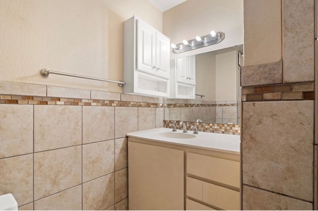 bathroom featuring vanity and tile walls