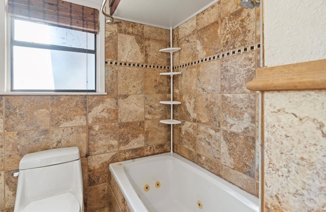 bathroom with toilet and tiled shower / bath