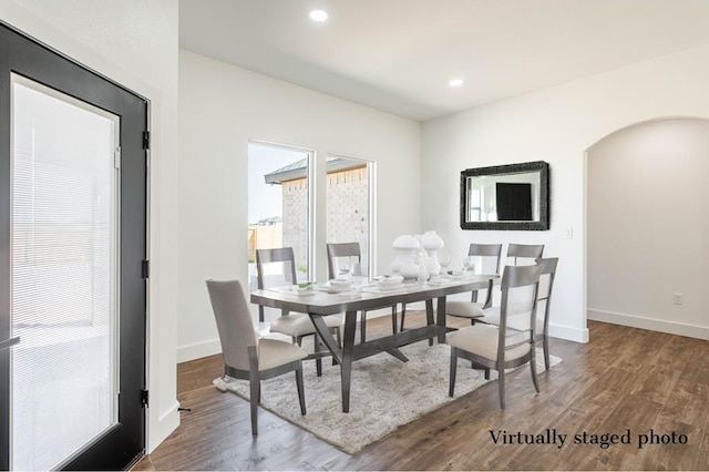 dining room featuring arched walkways, dark wood-type flooring, recessed lighting, and baseboards