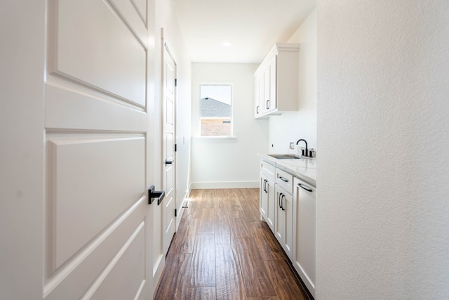 interior space featuring baseboards, dark wood finished floors, and a sink