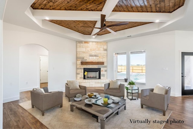 living area with a raised ceiling, wood finished floors, wood ceiling, and baseboards