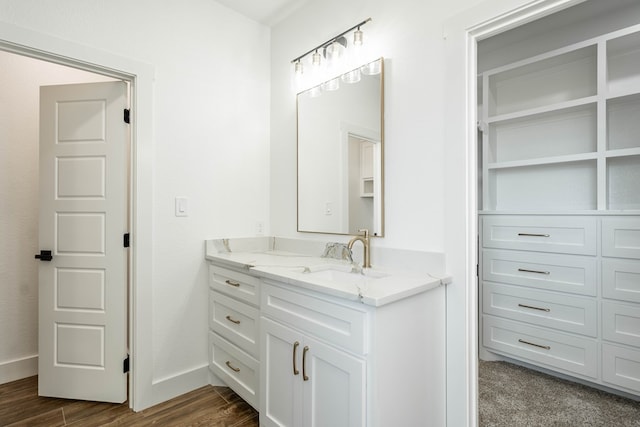 bathroom featuring baseboards, wood finished floors, and vanity