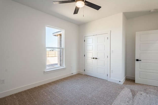 unfurnished bedroom featuring light carpet, a closet, a ceiling fan, and baseboards