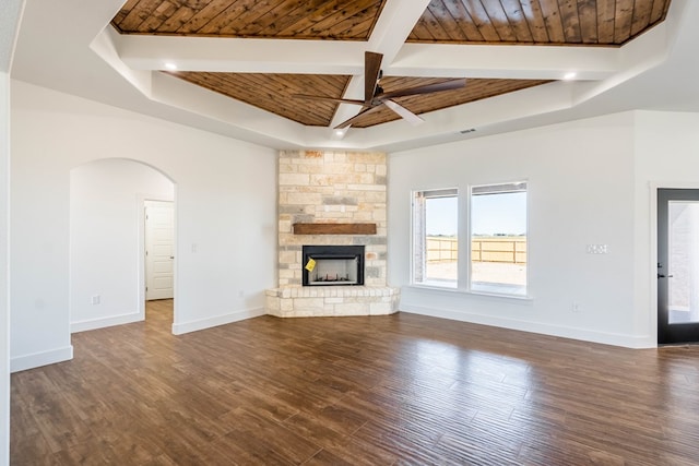 unfurnished living room featuring wooden ceiling, dark wood-style flooring, a fireplace, baseboards, and beamed ceiling