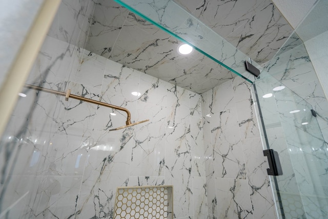 interior details featuring a marble finish shower