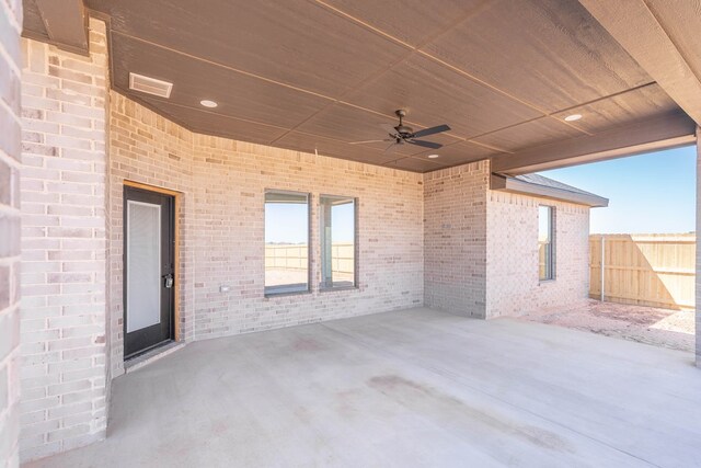 view of patio featuring ceiling fan, fence, and visible vents