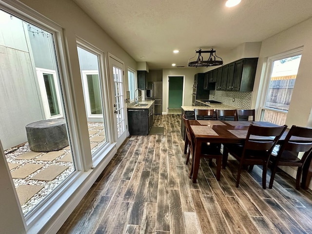 dining area featuring a textured ceiling, sink, and dark wood-type flooring