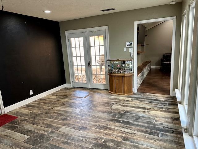 entryway featuring french doors, a textured ceiling, and dark hardwood / wood-style floors