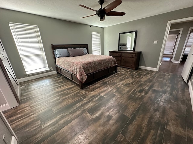 bedroom with ceiling fan, dark hardwood / wood-style flooring, and a textured ceiling