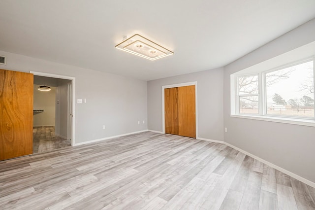 unfurnished bedroom with light wood-style floors, baseboards, and a closet