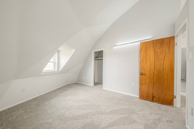 additional living space with vaulted ceiling, carpet floors, and baseboards