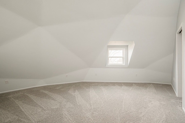 bonus room featuring vaulted ceiling and carpet flooring