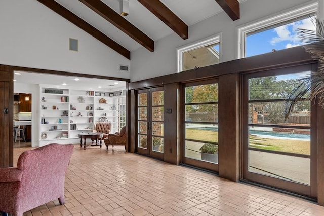 doorway with high vaulted ceiling, brick floor, visible vents, and beam ceiling