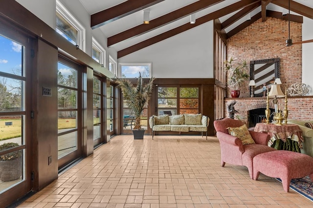 sunroom / solarium with lofted ceiling with beams and a fireplace