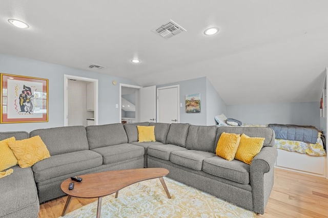 living room featuring lofted ceiling, light wood-type flooring, visible vents, and recessed lighting