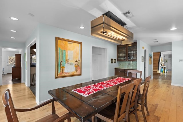 dining space featuring a bar, recessed lighting, visible vents, and light wood-style floors