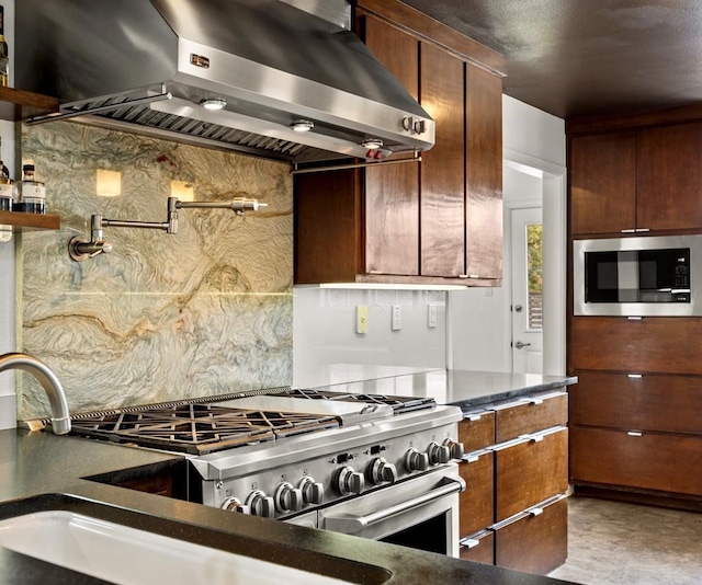 kitchen with appliances with stainless steel finishes, decorative backsplash, and ventilation hood