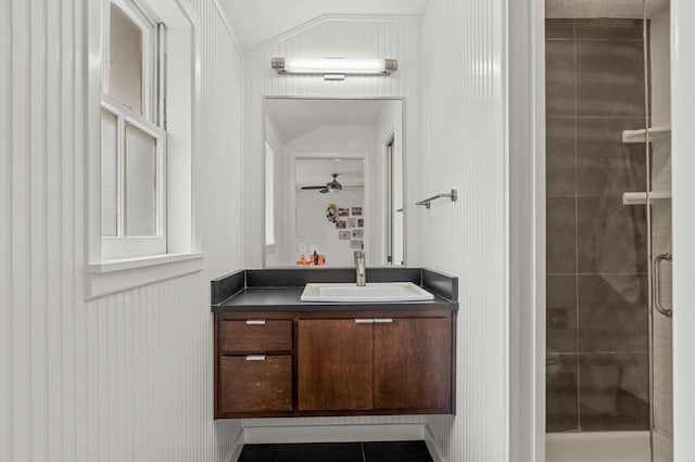 full bath with a stall shower, lofted ceiling, ceiling fan, tile patterned flooring, and vanity