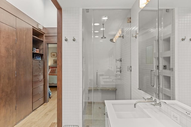 full bathroom with a shower stall, tile walls, and vanity