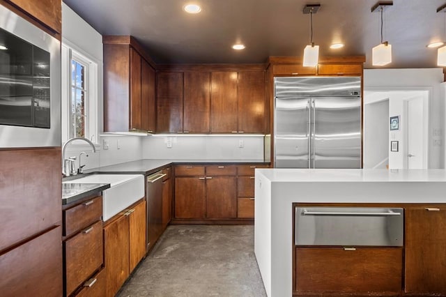 kitchen with decorative light fixtures, a warming drawer, appliances with stainless steel finishes, a sink, and concrete floors