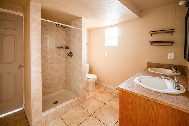 3114 Thomas Ave, Midland, TX 79701 - bathroom featuring double vanity, tile patterned flooring, a tile shower, and a textured ceiling