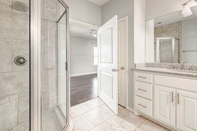 full bath featuring a shower stall, baseboards, a ceiling fan, and vanity
