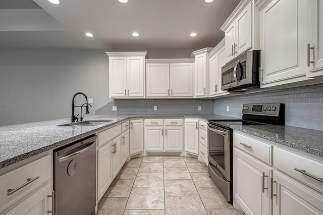 kitchen with backsplash, appliances with stainless steel finishes, a sink, and recessed lighting