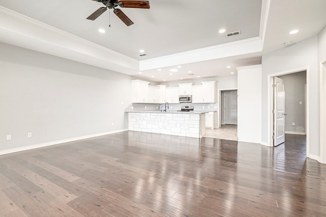 unfurnished living room with a ceiling fan, crown molding, and a raised ceiling