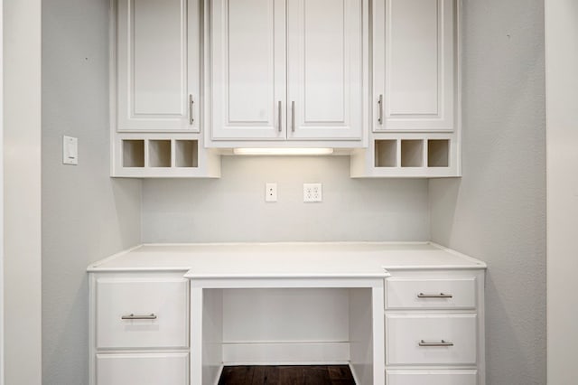 interior space with built in study area and wood finished floors