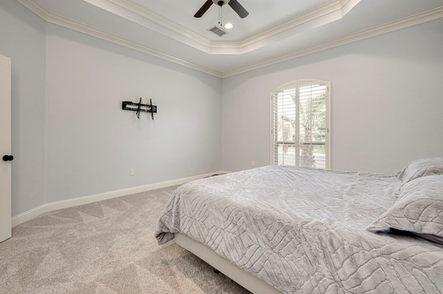 carpeted bedroom featuring visible vents, ornamental molding, baseboards, a raised ceiling, and a ceiling fan