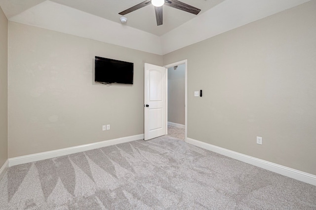 empty room featuring baseboards, ceiling fan, and light carpet