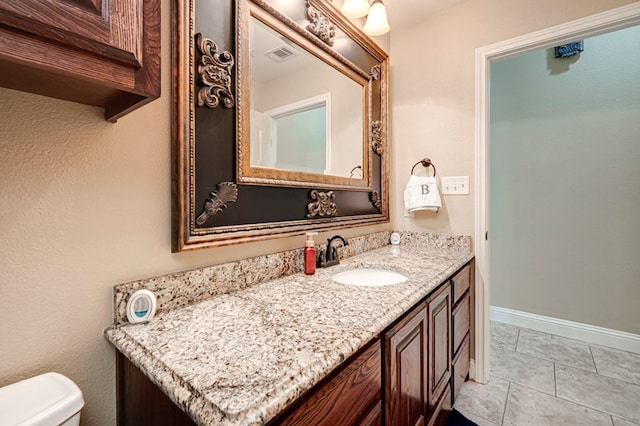 bathroom featuring vanity, baseboards, toilet, and visible vents