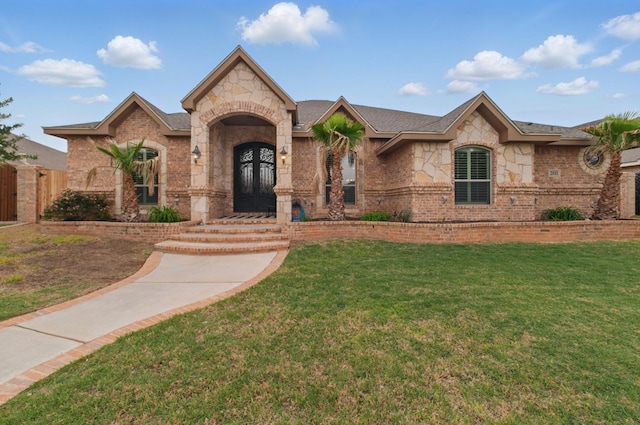 view of front of property featuring brick siding, a front lawn, and stone siding