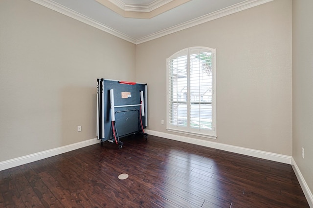 spare room featuring baseboards, ornamental molding, and wood finished floors