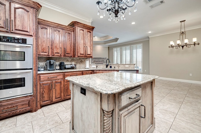 kitchen featuring visible vents, ornamental molding, appliances with stainless steel finishes, and a notable chandelier