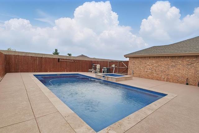 view of pool featuring a fenced backyard, a pool with connected hot tub, and a patio area