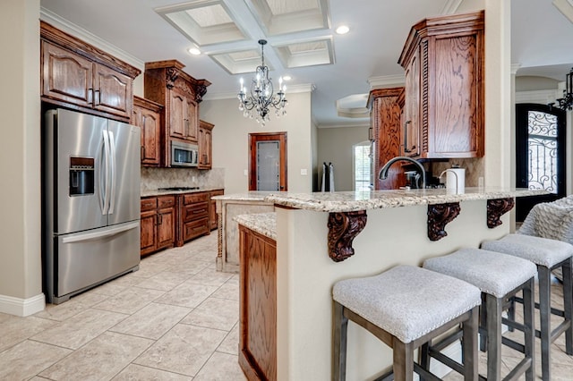 kitchen with crown molding, decorative backsplash, a peninsula, appliances with stainless steel finishes, and a notable chandelier