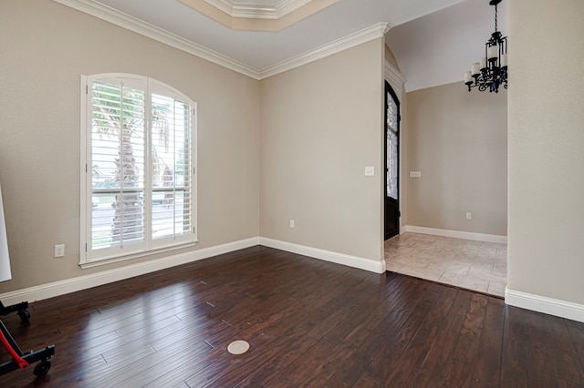 empty room with crown molding, baseboards, a notable chandelier, and dark wood-type flooring