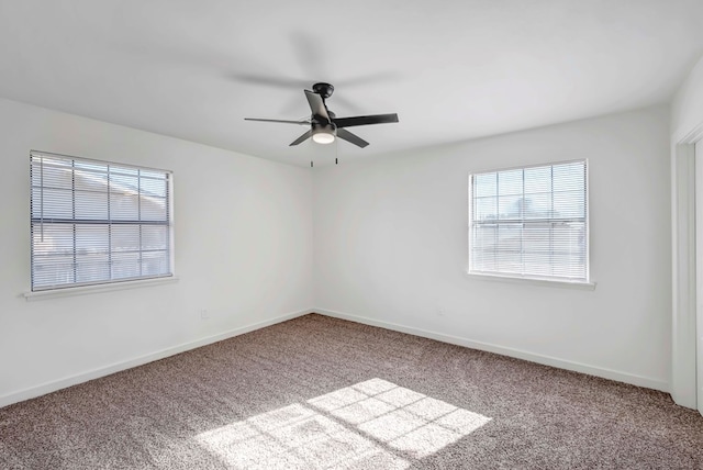 carpeted empty room featuring ceiling fan and plenty of natural light