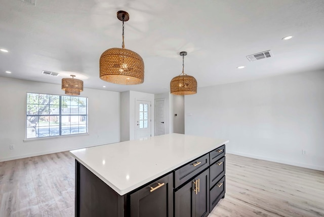 kitchen featuring pendant lighting, light hardwood / wood-style flooring, and a center island