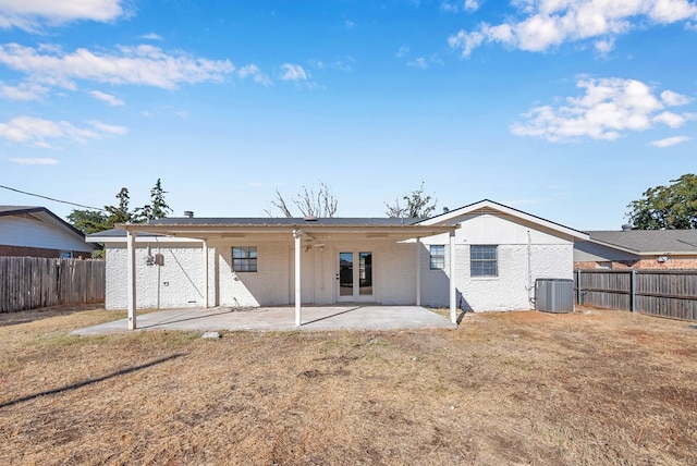 rear view of property with central AC unit, a yard, a patio area, and french doors