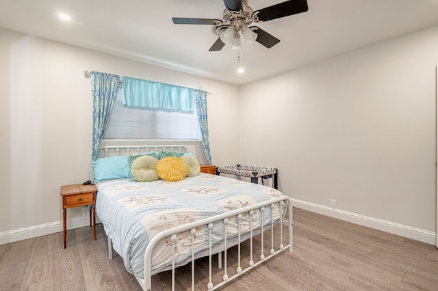 bedroom with light wood finished floors, a ceiling fan, baseboards, and recessed lighting