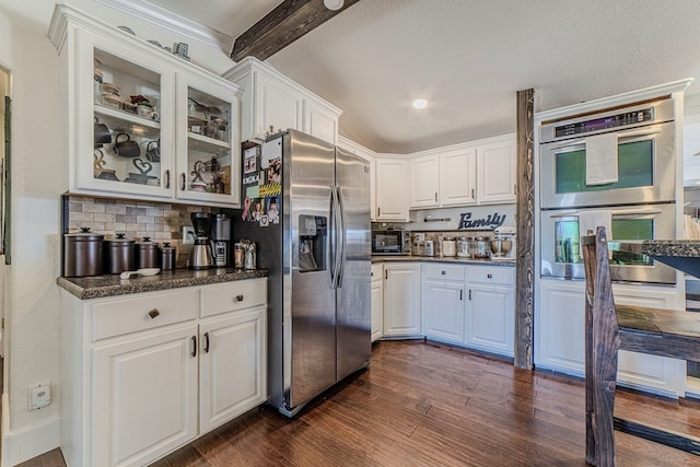 kitchen featuring backsplash, white cabinets, appliances with stainless steel finishes, beamed ceiling, and dark hardwood / wood-style flooring